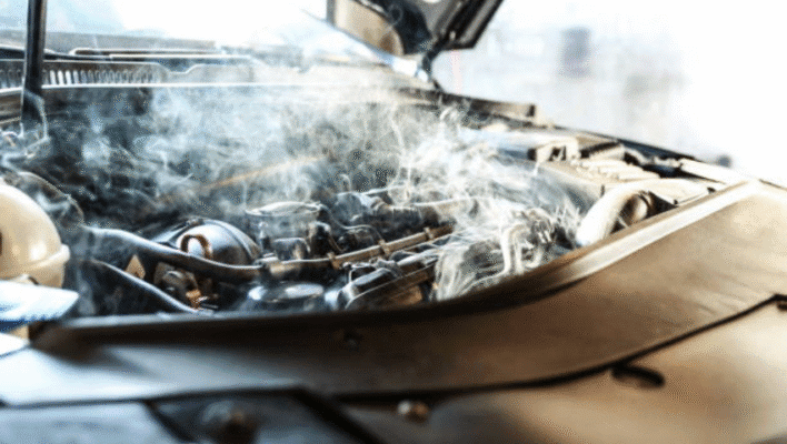 A smokey car engine shows signs of a lack of maintenance.